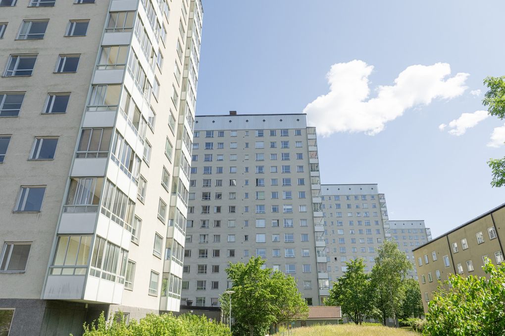 Tre vita höghus och ett gult låghus.