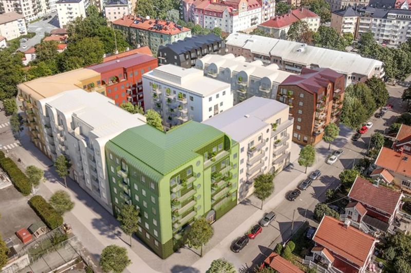 Ritad visionsbild över nya kvarteret Bollen med flerfamiljshus på cirak fem våningsar i olika färgnyanser som grönt, vitt, gult, rött och svart med gator runt om och grönskande träd.