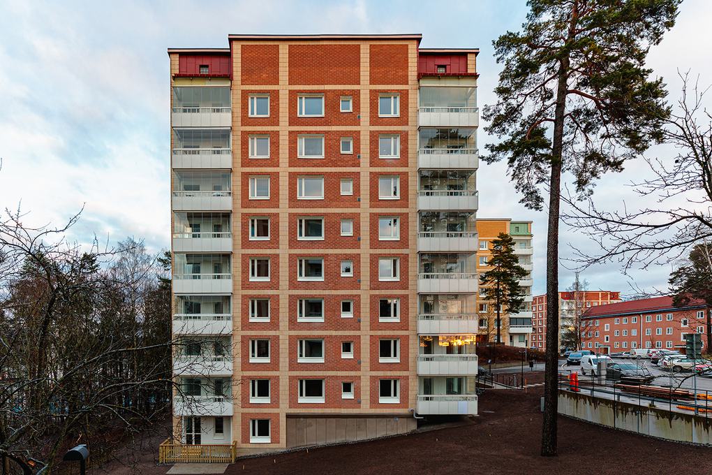 Ett av de nyrenoverade husen i Ritorp som har rödbrunt tegel med vita balkonger.